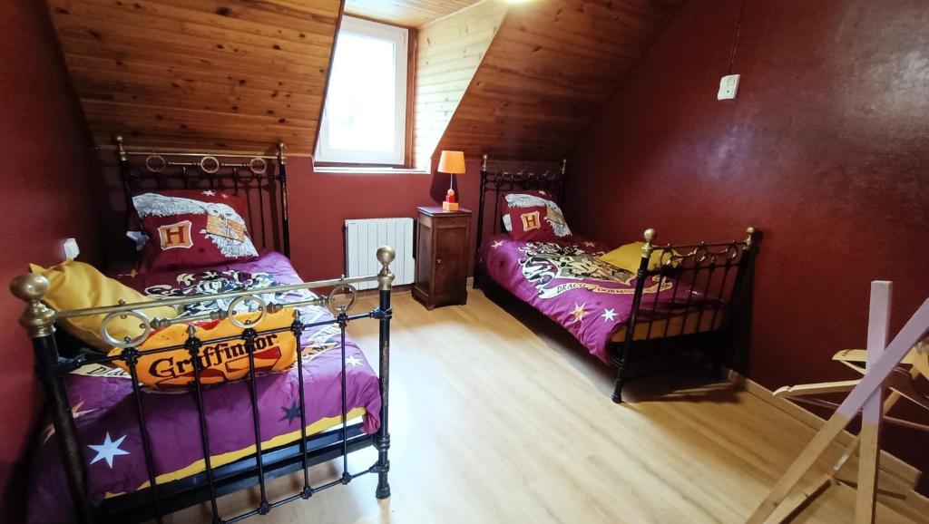 a attic room with two beds and a window at Le Chaudron de Loguivy in Loguivy-Plougras