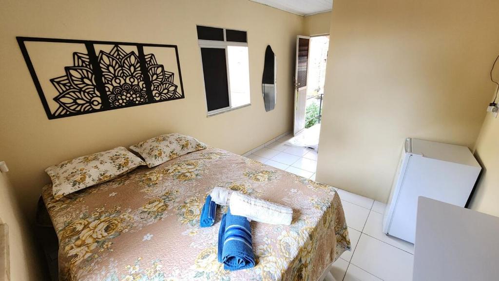 a room with a bed with a blue pipe on it at Suíte Conforto - Leve, Prático e Acolhedor in Itacaré