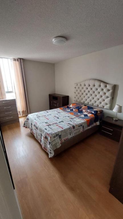 a bedroom with a bed with a quilt on it at Apartamento Varela in Lima