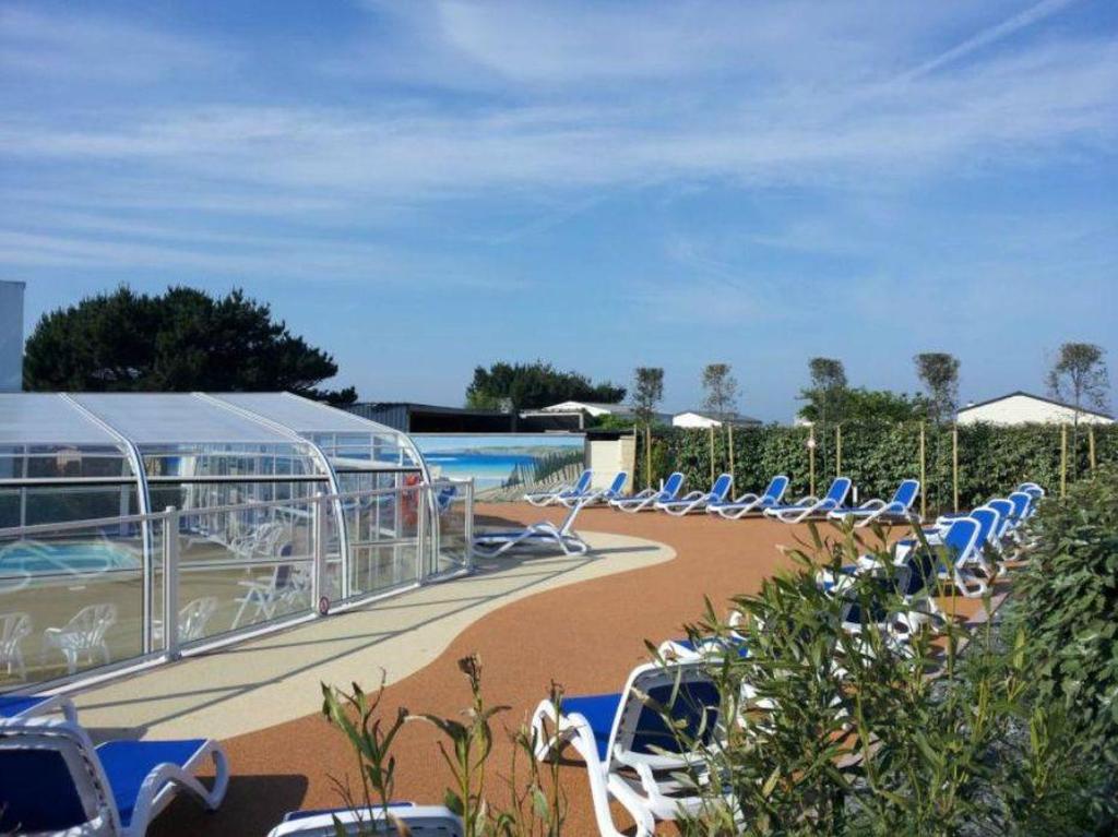 a group of chairs sitting next to a swimming pool at Camping La Pointe du Talud in Ploemeur