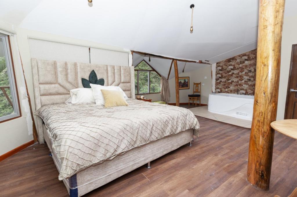 a bedroom with a large bed and a bathroom at Caisae Eco-Lodge in San Antonio