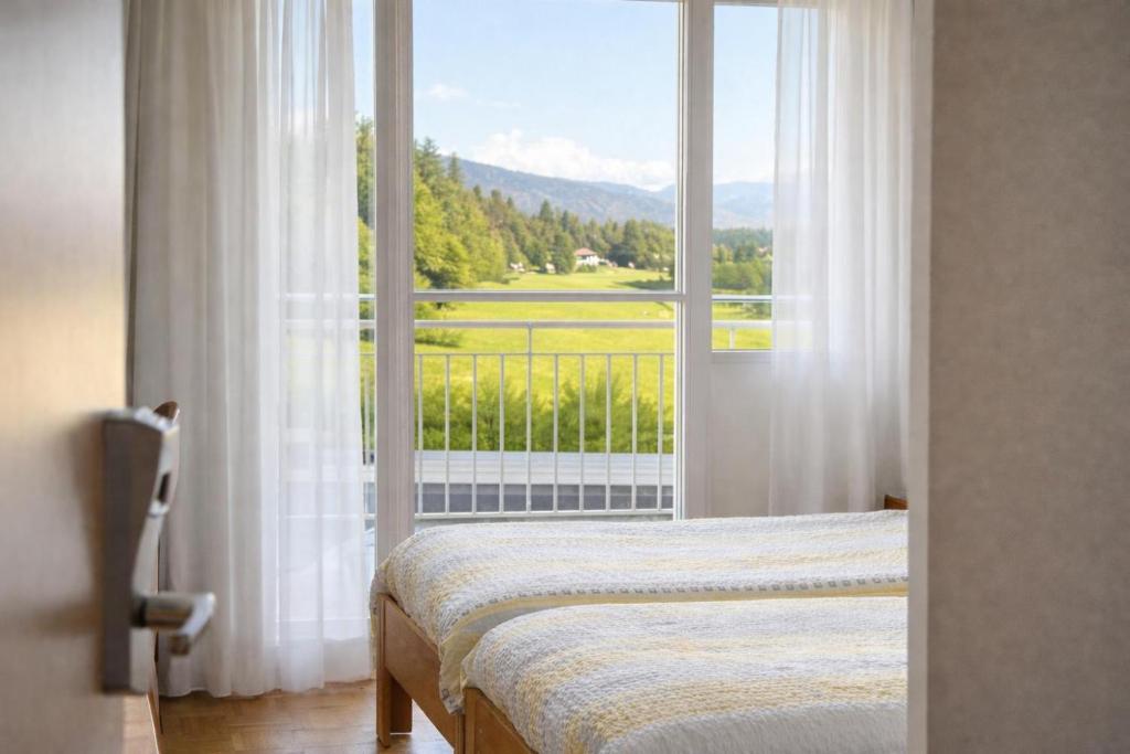 a bedroom with a bed and a large window at Hôtel La Croisée Neuchâtel in Malvilliers