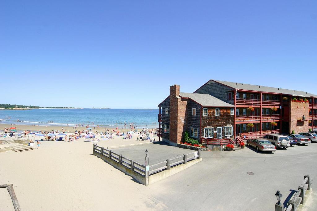 a beach with a building and people on the beach at Cape Ann Motor Inn in Gloucester