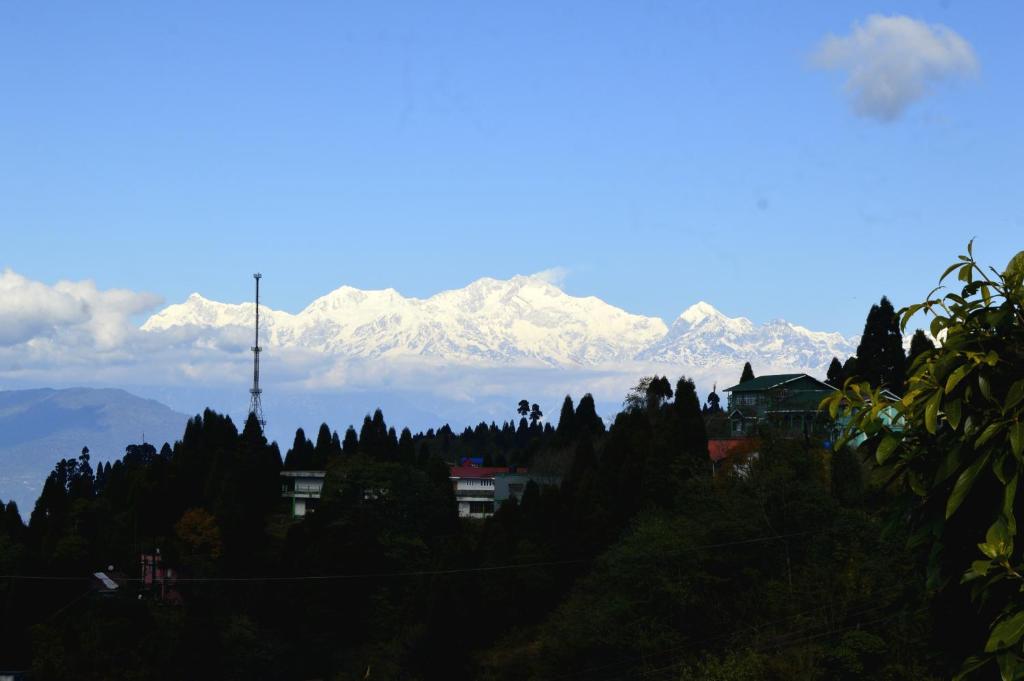 a view of a mountain range with snow covered mountains at Tenzin's Inn in Jālāpahār