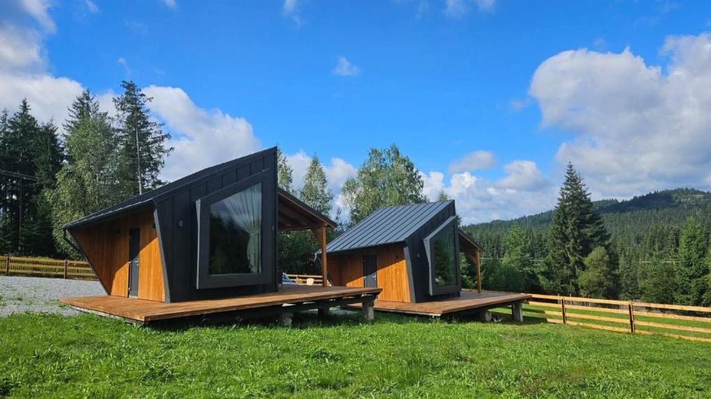 a couple of tiny houses sitting on top of a field at Nord Hill in Poiana Negrii