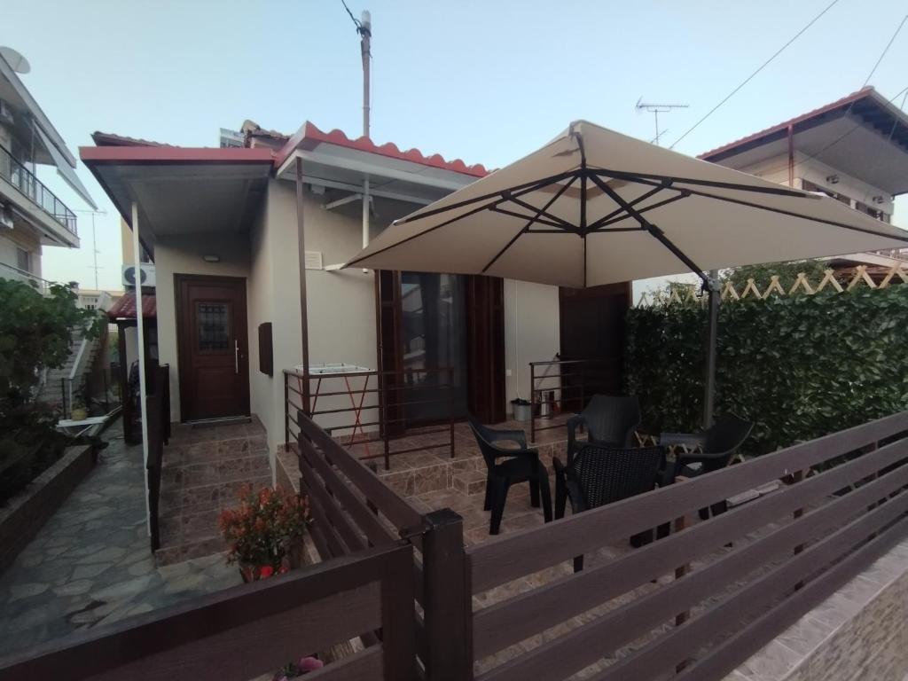 a patio with a table and an umbrella at Αίγλη Apartment in Ierissos