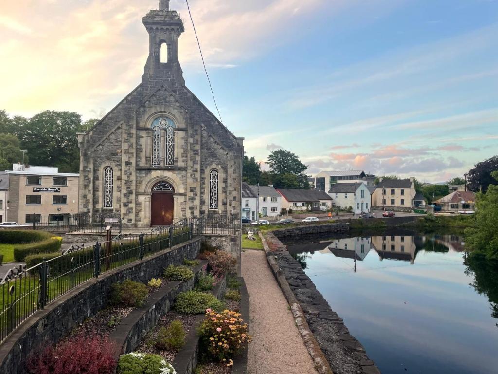 an old church with a reflection in the water at Riverside House in Donegal