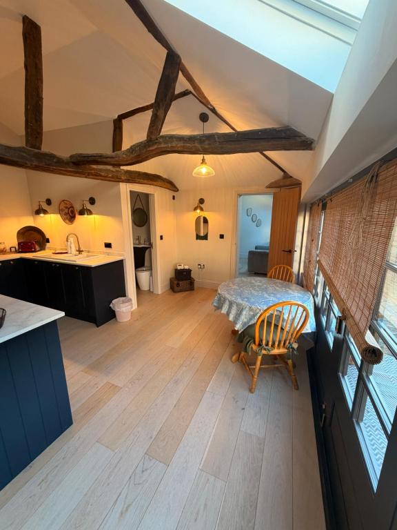 a kitchen and living room with a bed and wooden floors at The stables at the Grange in York