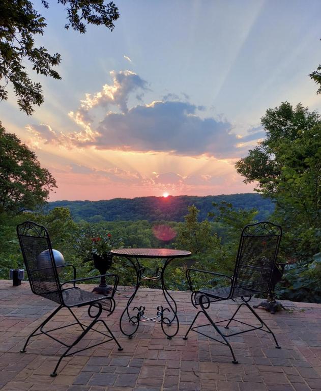 a table and two chairs on a patio with the sunset at St. Croix Valley Inn in Shafer
