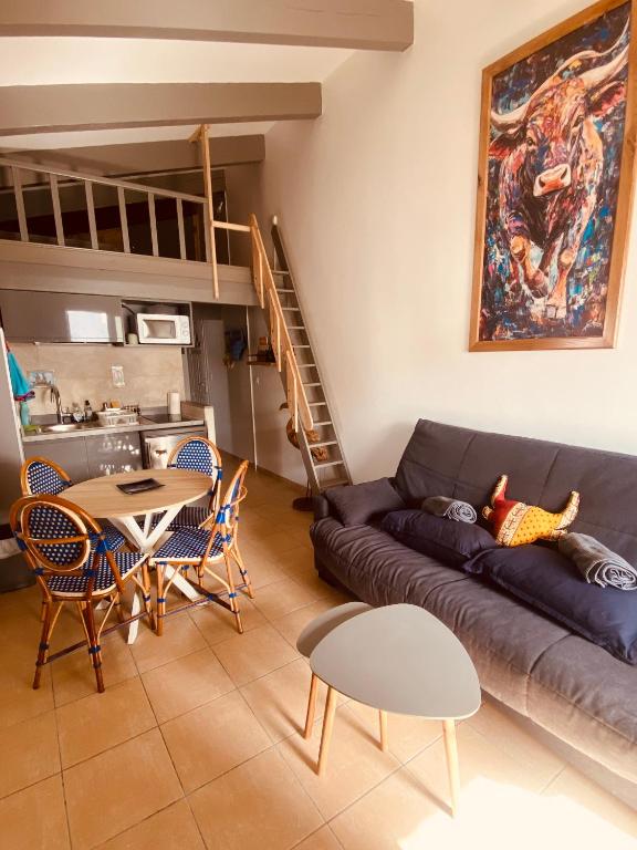 a living room with a couch and a table at Un cocon en Camargue in Saintes-Maries-de-la-Mer