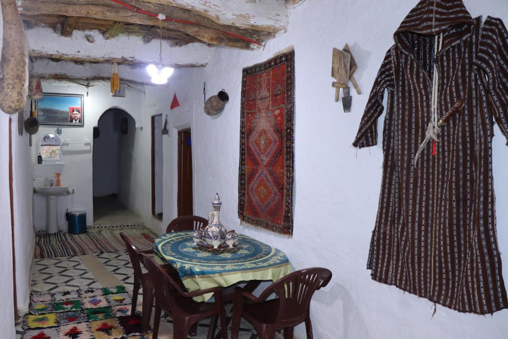 a dining room with a table and chairs in a room at Gîte OUHDOU in Midelt