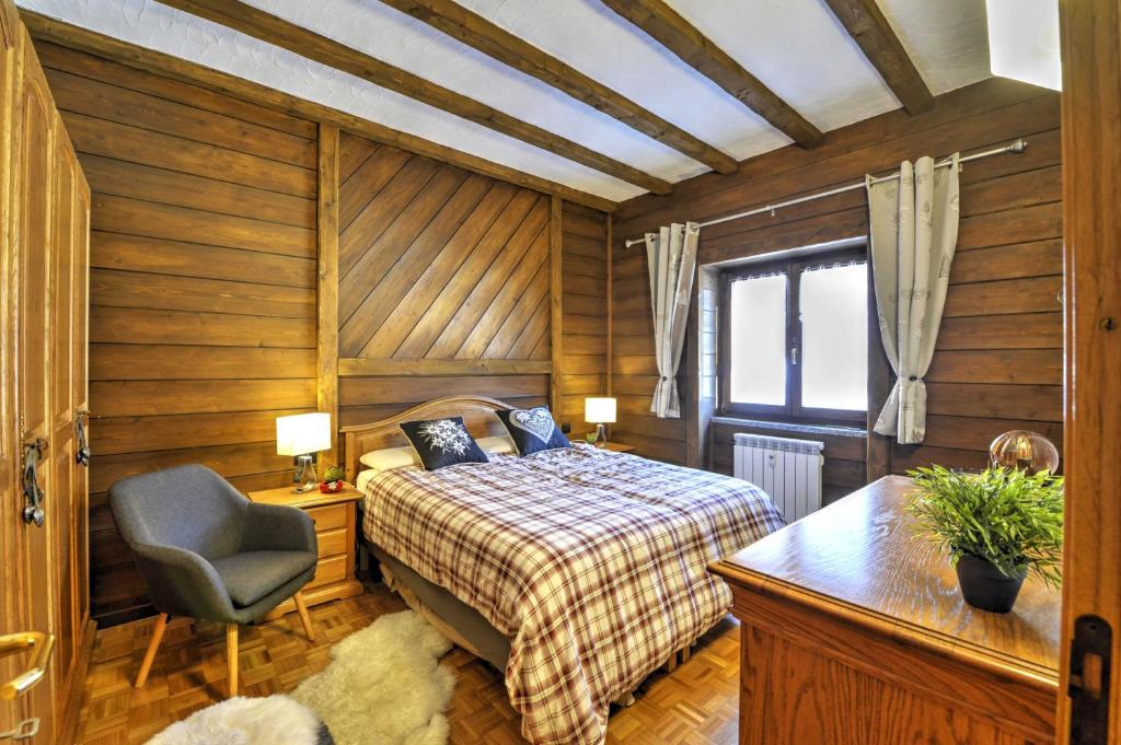 a bedroom with a bed and a chair and a window at Anima Alpina in Morgex