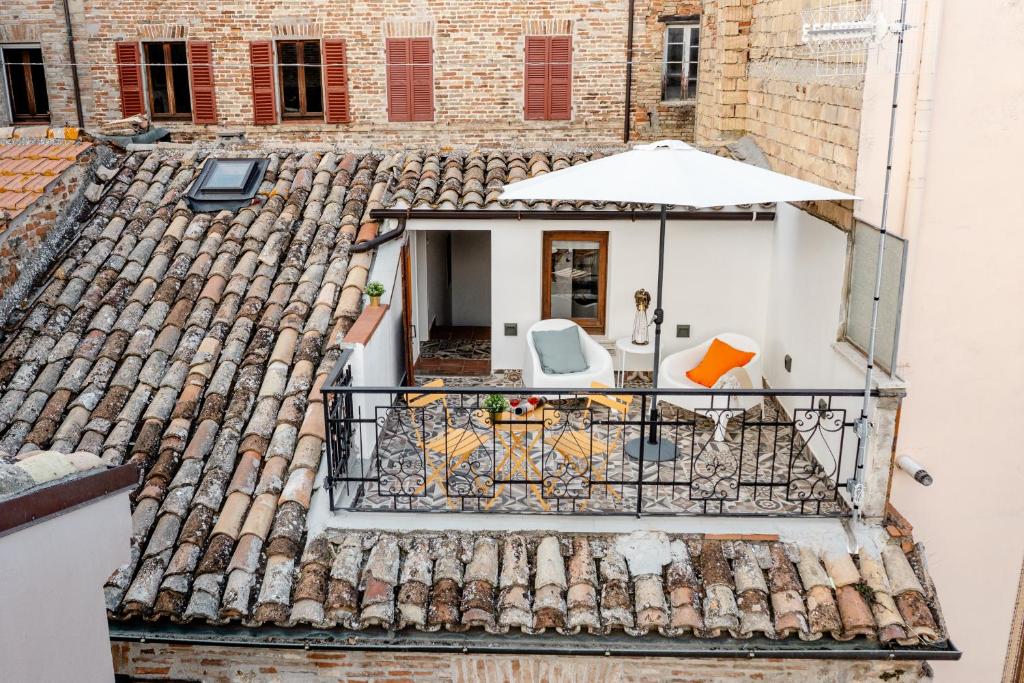an aerial view of a roof with a patio and an umbrella at Casa GAH Ripatransone Suite nel Borgo tra Mare e Calanchi in Ripatransone