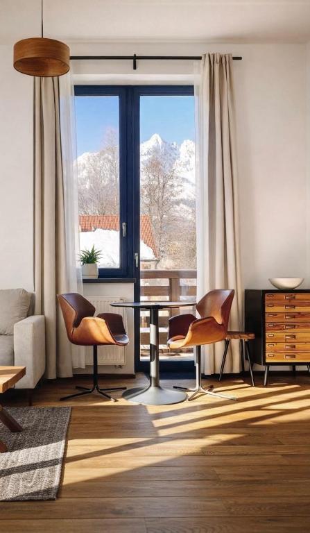 a living room with a table and chairs and a window at Apartment Loft Lomnica in Tatranská Lomnica