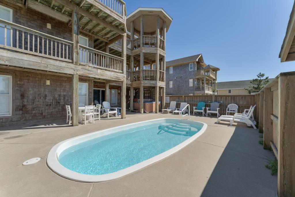 a pool in the backyard of a house with a building at 5469 - Below Deck OBX in Nags Head