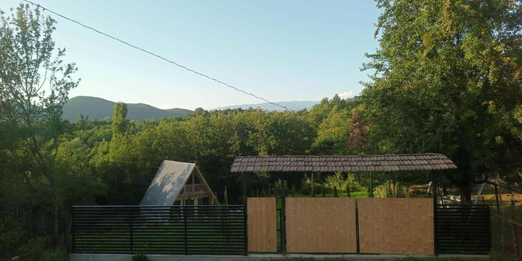 a building with a fence in front of a forest at vila pataraia in Martvili