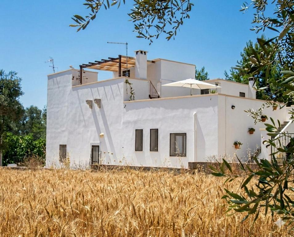 a white house sitting in a field of grass at Agriturismo Tenuta La Siesta in Gallipoli