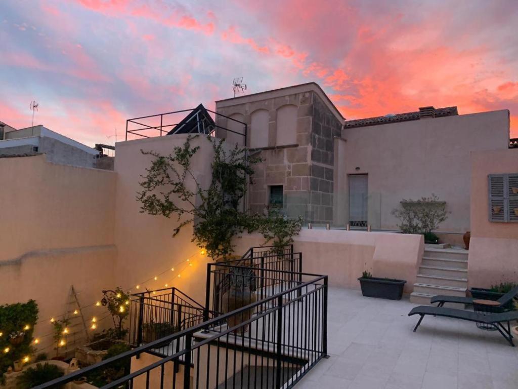 a building with a sunset in the background at s'Herència in Porreres