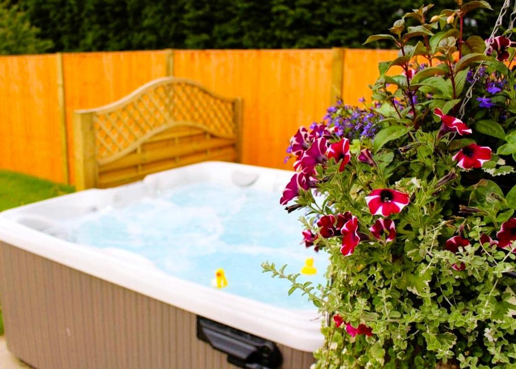 a jacuzzi tub with a bench and a flower pot at Beech Tree Park Cottages in Hatfield