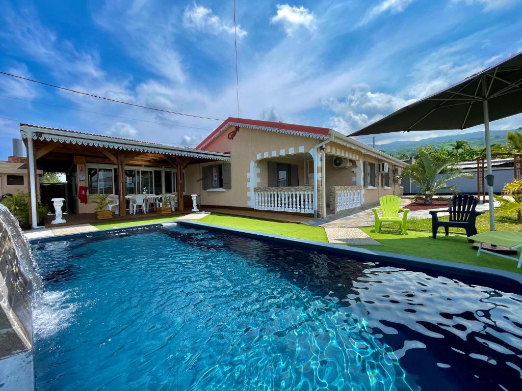 a swimming pool in front of a house at La Kaz Baz ' île in Étang-Salé