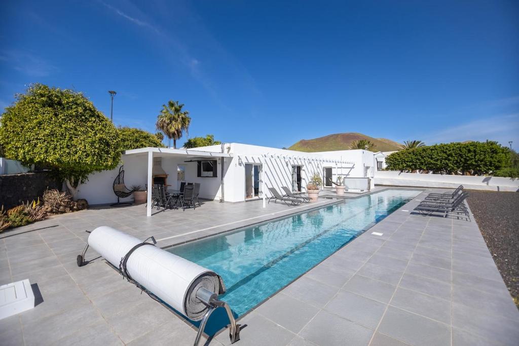a swimming pool in front of a house at Casa Conil Private 25m Heated Pool with Hydraulic Mobility Lift in Conil