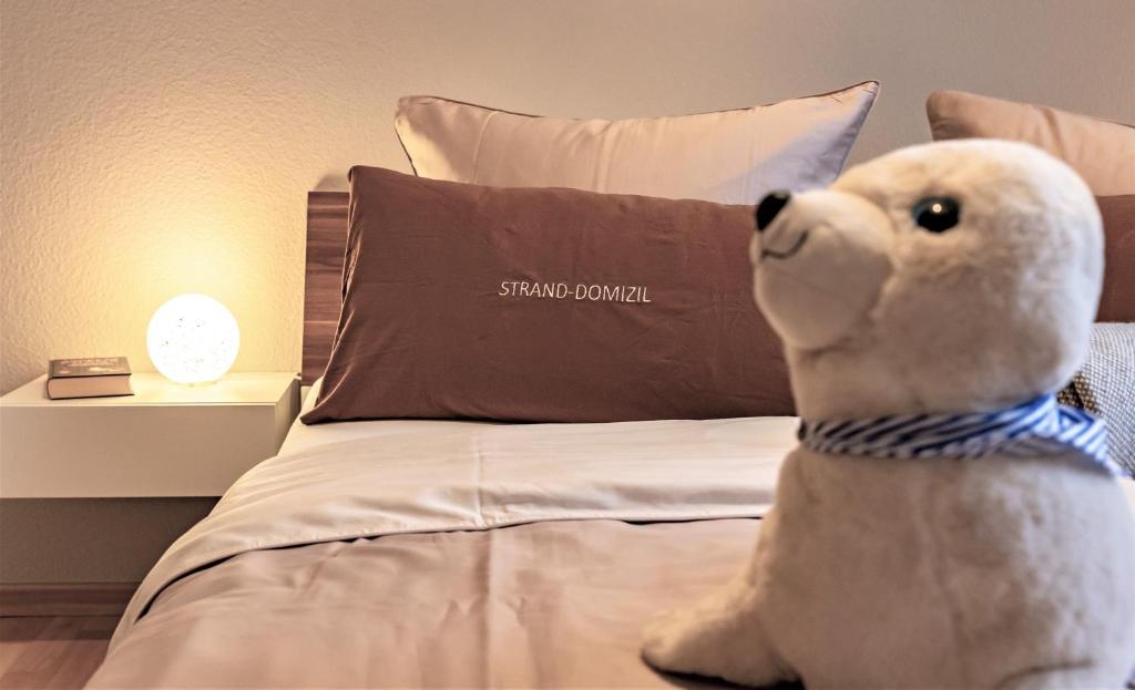 a stuffed polar bear sitting on a bed at Ferienwohnung Strand-Domizil Zingst in Niederdorla