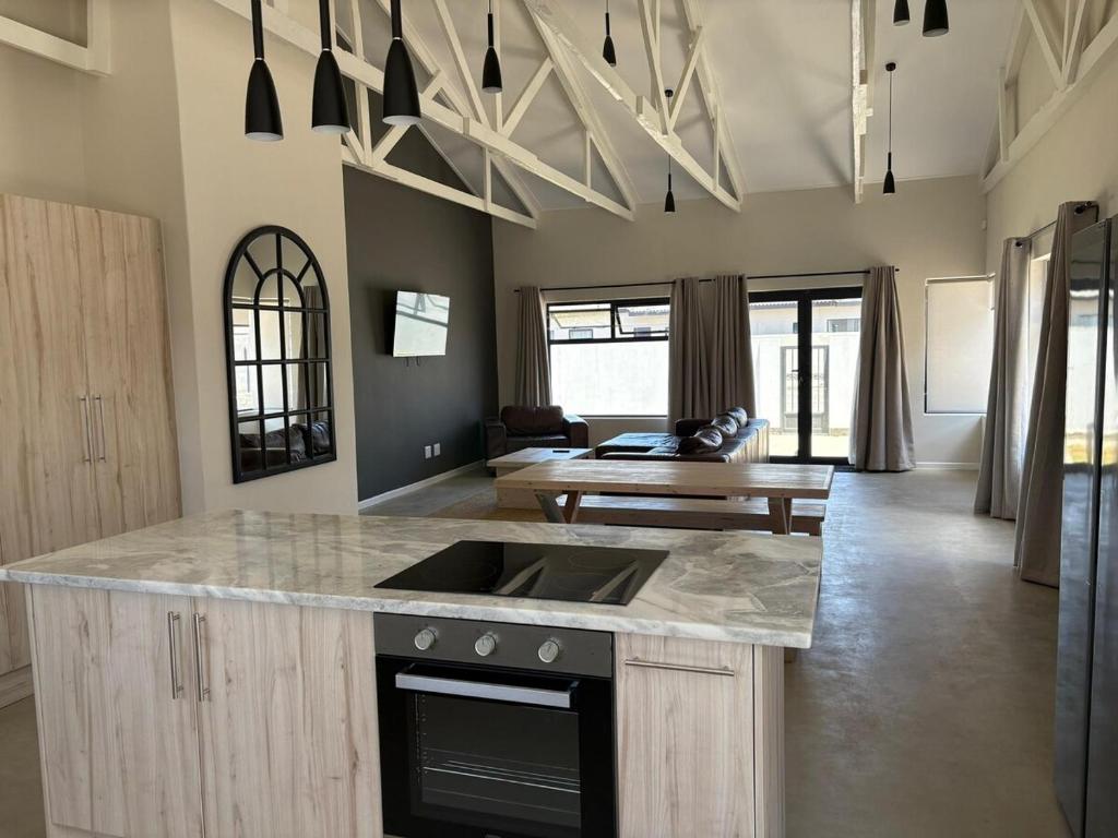 a kitchen with a counter top and a living room at House Stillmar in Walvis Bay