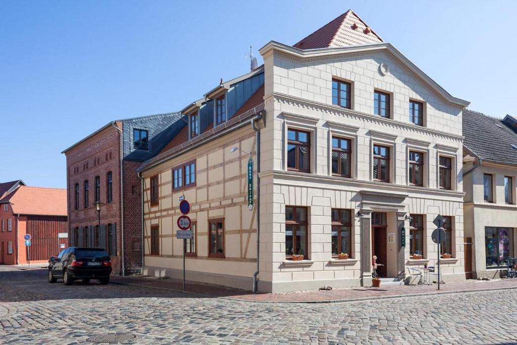 ein großes weißes Gebäude an der Ecke einer Straße in der Unterkunft Hotel Haus Sajons in Plau am See