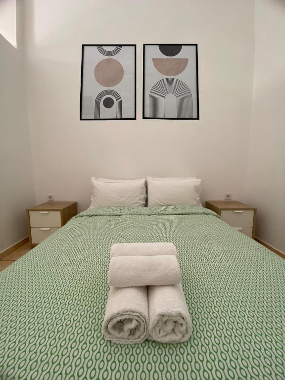a bedroom with a bed with two towels on it at Sisifou Apartment in Korinthos