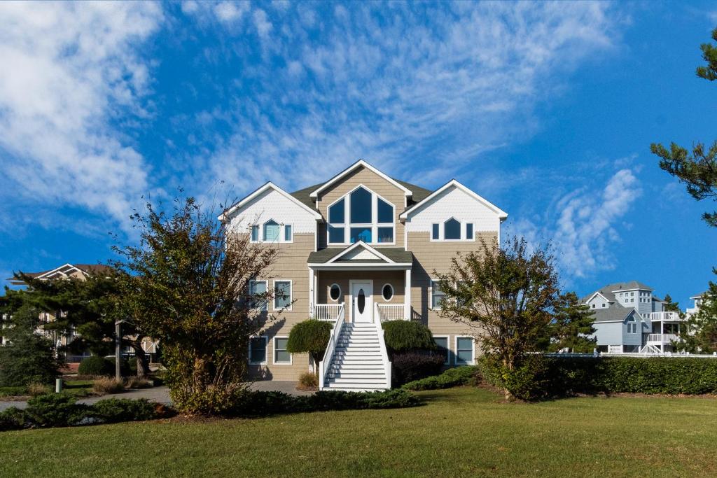 a house with a white staircase in a yard at 4052 - Mirth N Mist II in Duck