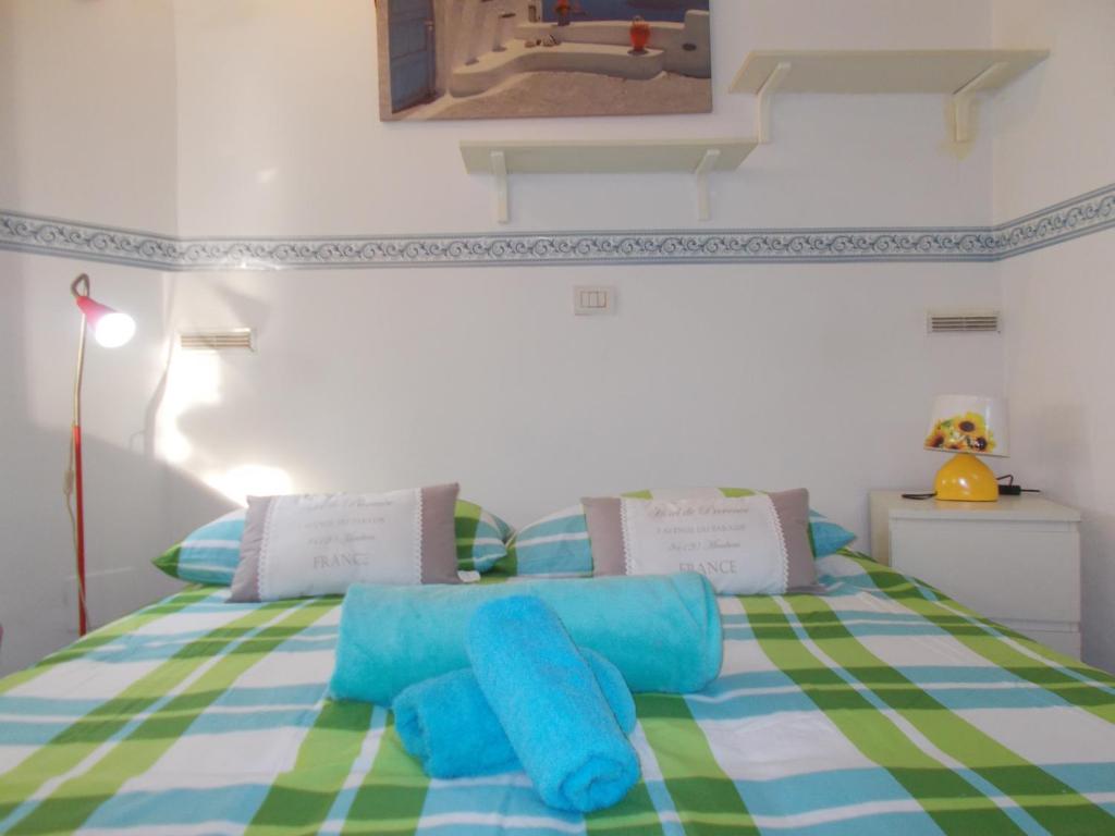 Un dormitorio con una cama verde y blanca con almohadas azules en Il Granello di Senape B&B, en Palazzo Canavese