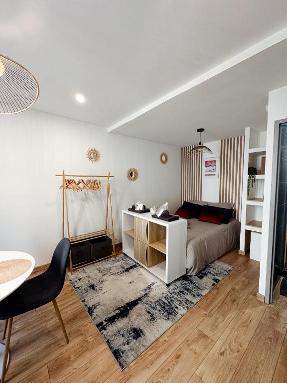 a bedroom with a bed and a desk and a table at Le Repaire blterrois in Béziers