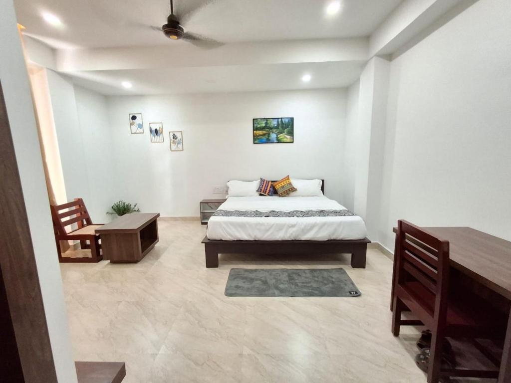 a bedroom with a bed and a table and a desk at The Rustic Inn Kaziranga in Kāziranga