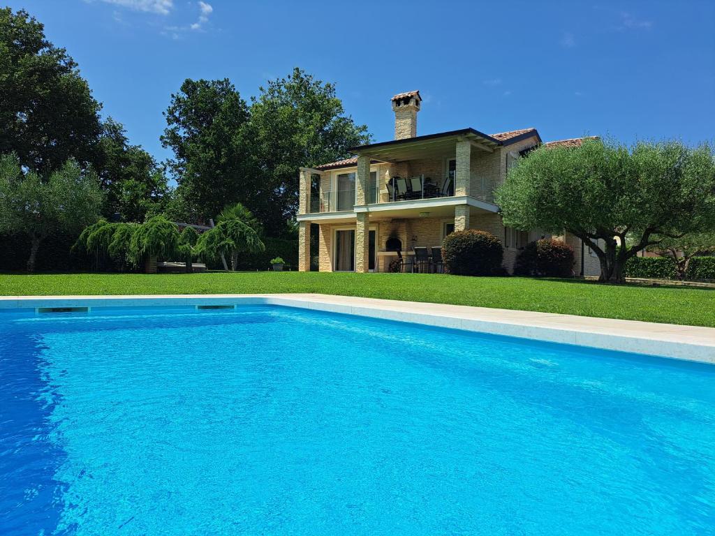 a large swimming pool in front of a house at Apartments Villa Sotlar with pool in Umag
