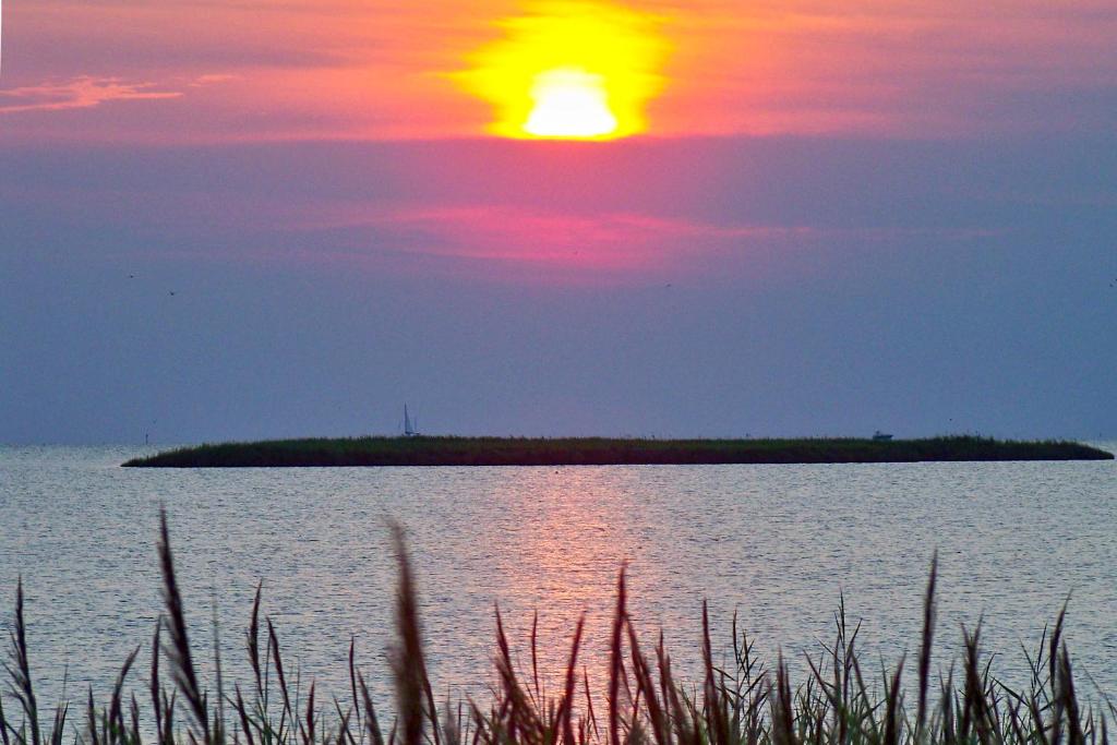 an island in the middle of a lake with a sunset at C103A - Sweet Sound Memories in Nags Head