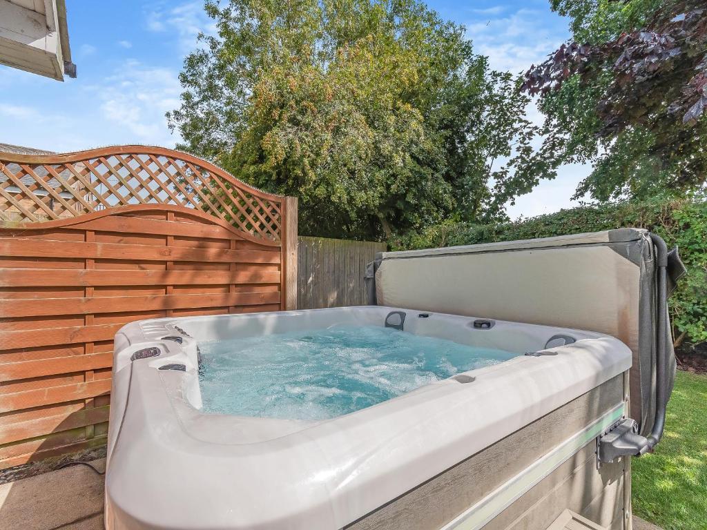 a hot tub in a backyard with a fence at Ted's Place in Bridlington