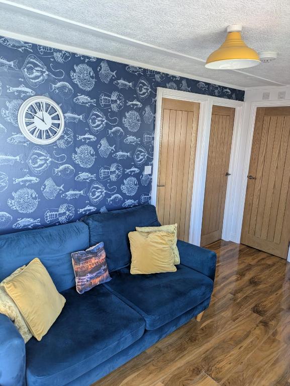 a blue couch in a living room with a wall at Savannah-by-the-sea in Bridlington
