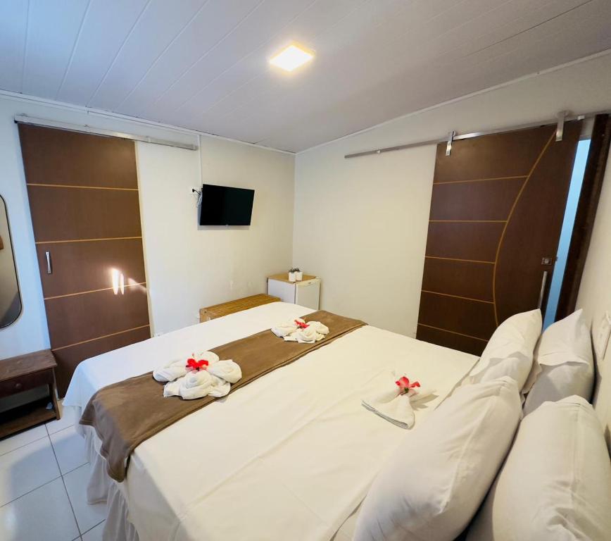 a hotel room with a large bed with towels on it at Pousada do Trinta in Fernando de Noronha