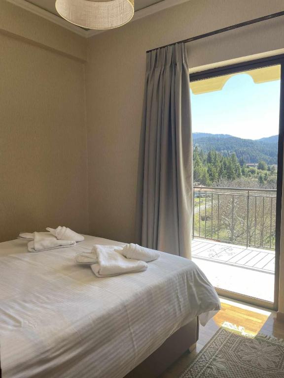 a bedroom with a bed and a large window at Village House by nature in Karkaloú