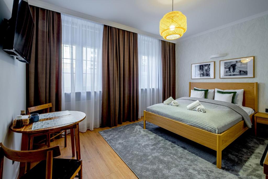 a bedroom with a bed and a table and a television at Balans Studio Old Town I in Gdańsk