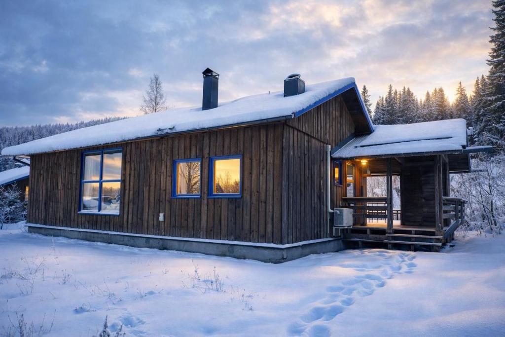 a wooden cabin in the snow with snow covered trees at Skutstuga 6 - Gruvbacken Huså in Järpen