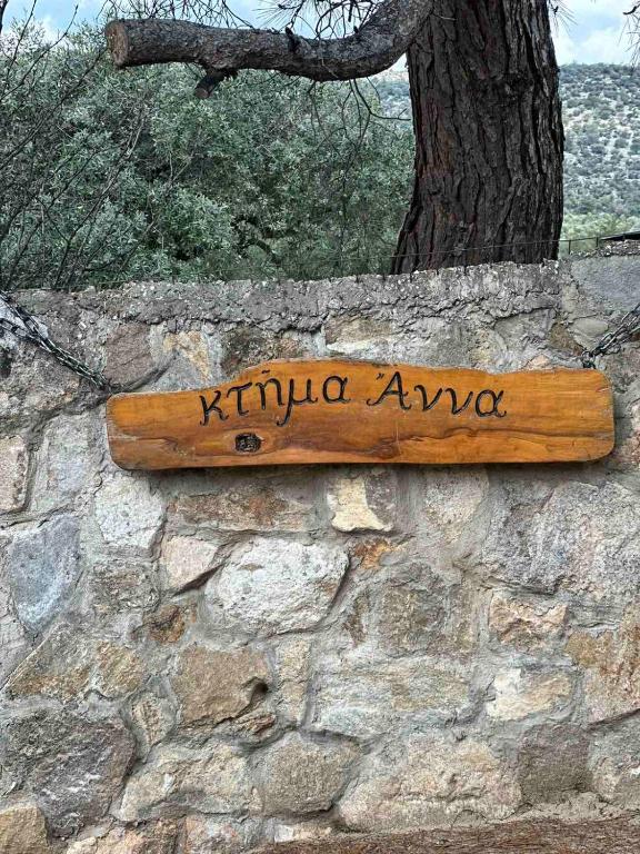 a wooden sign on a stone wall at Ktima Anna in Astris