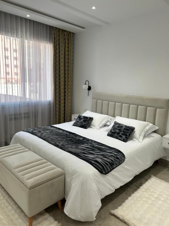 a bedroom with a large white bed and a window at Jasmine Apartment Tunis in Tunis