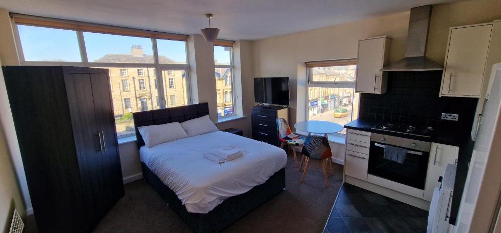 a small bedroom with a bed and a kitchen at SELF CHECK-IN PENTHOUSE APARTMENT in HALIFAX CENTRE in Halifax