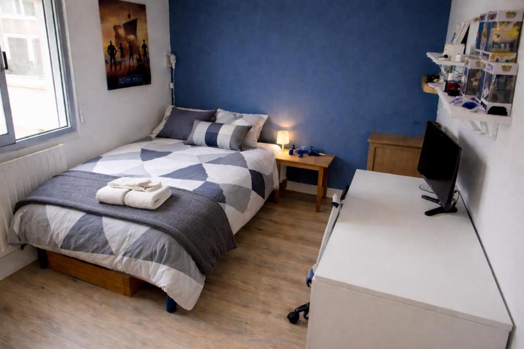a bedroom with a bed and a desk with a computer at Le chalet in Oullins