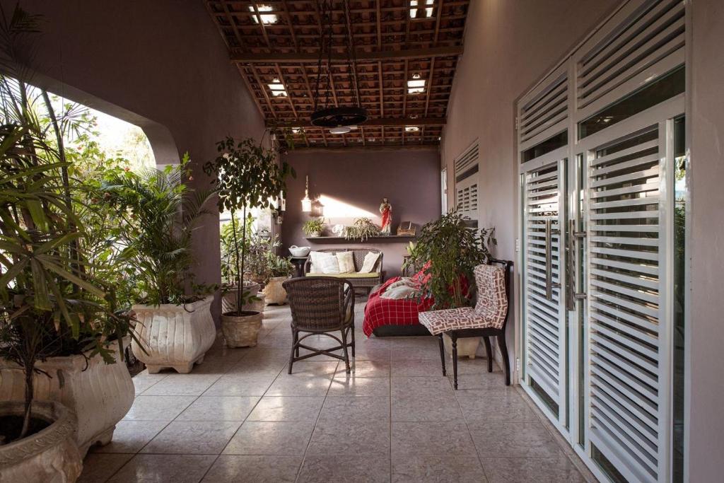 a room with plants and a table and chairs at Casa com Varanda, Quintal e Churrasqueira em Bonito PE in Bonito