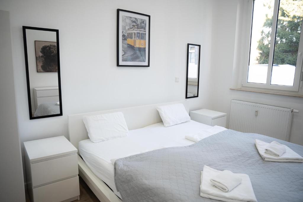 a white bedroom with a bed and two windows at Design Apartment - Solingen-Mitte - Balkon - BRIGHT Collection in Solingen