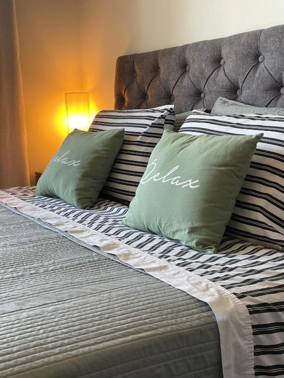a bed with two green pillows on it at Rosario SJ Loft Studio in Rosario