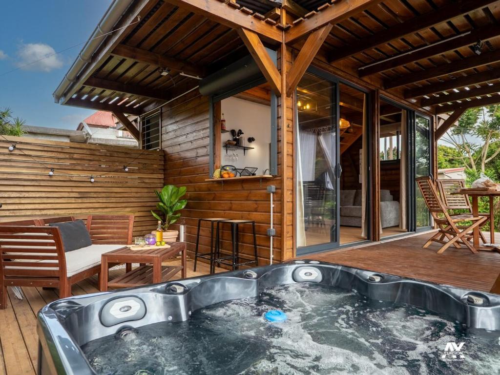 a hot tub on the deck of a house at Bungalow en duplex avec Jacuzzi in Sainte-Rose