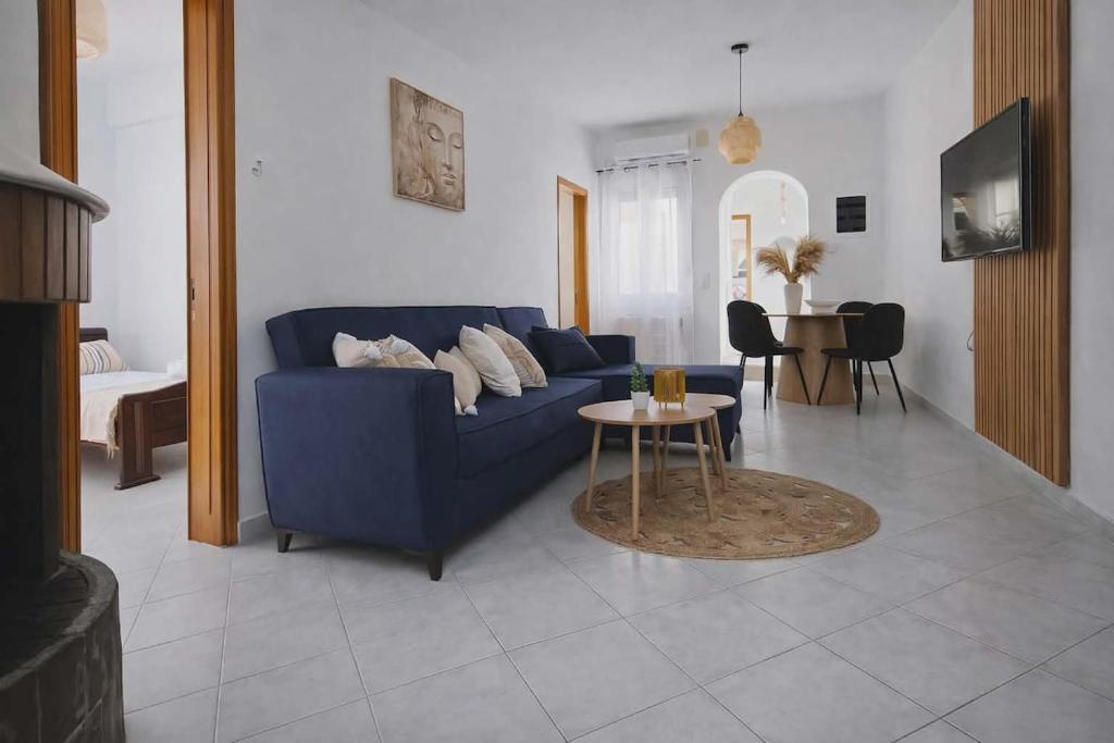 a living room with a blue couch and a table at LD Home in Lixouri